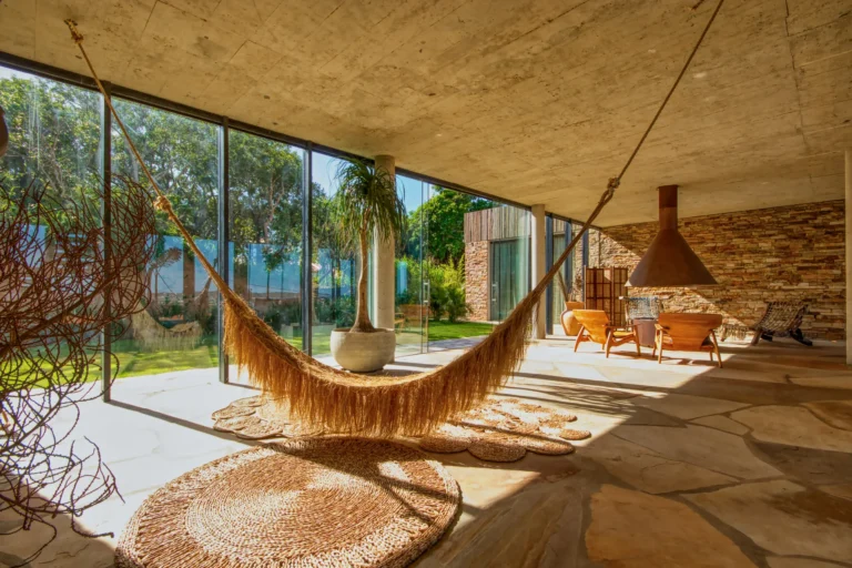 Ambiente residencial contemporâneo na Baía Formosa com rede, vidro e materiais naturais